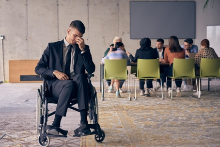 troubled businessman with disability excluded from meeting