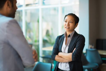 Young Asian professional woman crossing her arms during workplace dispute
